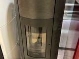 une cuisinière au milieu d'une pièce, avec un réfrigérateur derrière