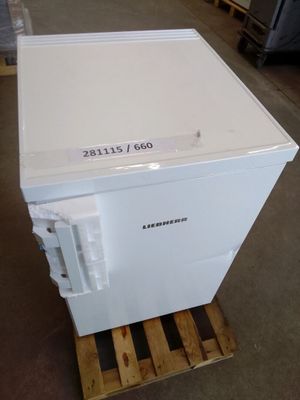 a white freezer sitting on a pallet in a warehouse