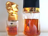 une image représentant un flacon de parfum à côté d'une statue en or
