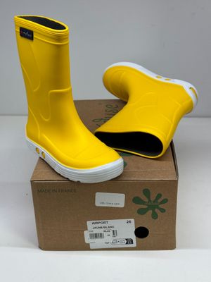 une paire de bottes de pluie jaunes posée sur une boîte en carton