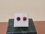 a close up of a pair of earrings on a marble block