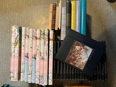 beaucoup de livres sur une étagère à côté d'une horloge
