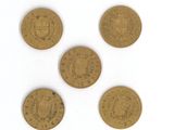 four gold coins are arranged in a row on a white surface
