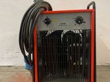 a red and black heater sitting on the floor next to a hose