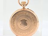 an image of a gold pocket watch on a clear display case