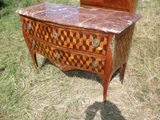 une commode au plateau en marbre au milieu d'un champ