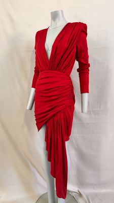 une robe rouge posée sur un présentoir à mannequin, sur fond blanc