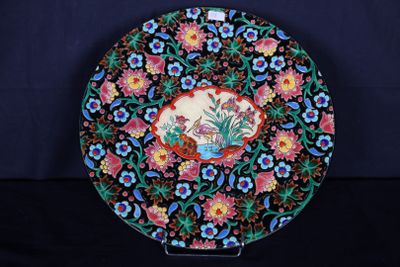 une assiette décorative ornée de fleurs et d'un oiseau