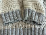 un pull en tricot et un bonnet en tricot posés sur une table