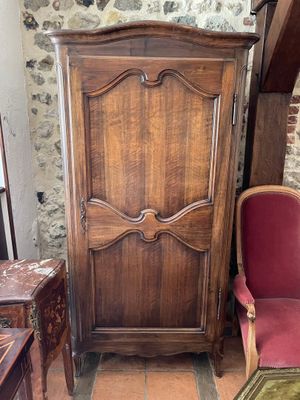 une armoire en bois devant laquelle se trouve une chaise rouge