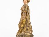 an old wooden statue of a woman with a hat and dress