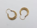 une paire de boucles d'oreilles en or sur fond blanc