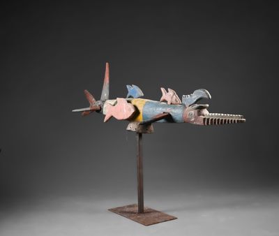 une sculpture représentant un avion de chasse, posée sur un socle métallique