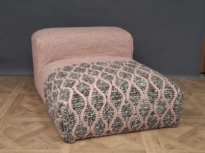 an upholstered footstof with a pink and grey pattern on it