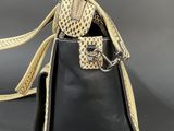 an image of a black and gold purse with a snake skin handle