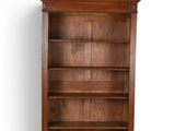 an image of a wooden bookcase on wheels against a white wall