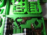 many different tools in a green case on a table