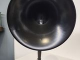 a black speaker on a stand on a white table