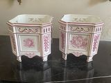 pair of pink and white porcelain planters on a black table