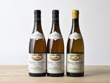 trois bouteilles de vin posées sur une table en bois