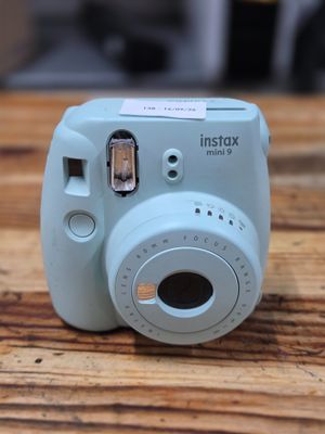a small blue camera sitting on a wooden table