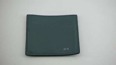un portefeuille en cuir vert posé sur une table blanche