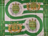 a green and white scarf with two coats of arms on it