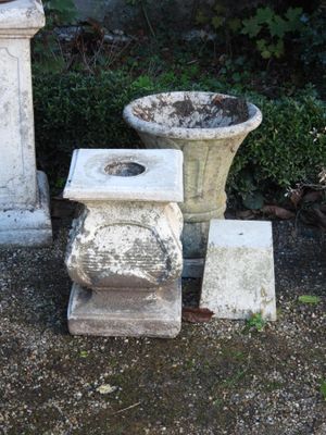 deux vases en ciment posés l'un à côté de l'autre par terre