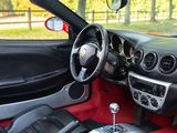 the interior of a sports car with red carpeting and black seats