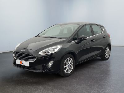 une voiture noire garée dans une pièce aux murs blancs