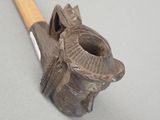 a small pipe with a wooden handle on a gray surface