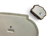 a small white plate with a blue flower on it