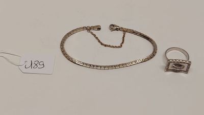 un bracelet et une bague en argent, accompagnés d'une chaîne, sur un fond blanc