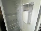 an open refrigerator that is sitting in the corner of the room