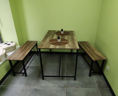 une table et des bancs dans une pièce aux murs verts