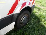 a white van with red stripes parked in the grass