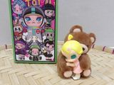 a stuffed animal that is sitting next to a box of toys