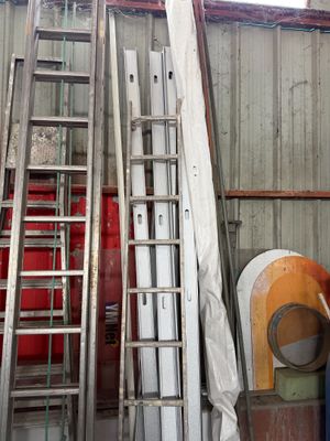 a ladder leaning up against a wall next to a pile of other items