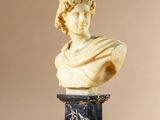 statue représentant le buste d'un homme sur un piédestal avec une base en marbre