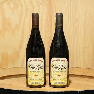 two bottles of wine sitting on top of a barrel