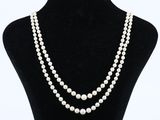a white pearl necklace on a black mannequin