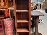 a tall wooden shelf with a mirror on top of it