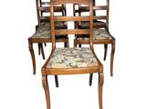 four wooden chairs with upholstered seats and a floral seat pad