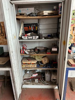 an open cabinet with tools on it in a garage