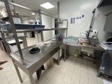 une cuisine avec des plans de travail en inox et un évier