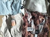 three shirts are sitting on a cardboard box with tags on them