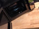 un micro-ondes posé sur une table en bois