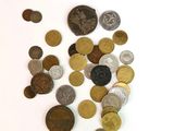 un tas de pièces de monnaie posées sur une surface blanche, sur fond blanc