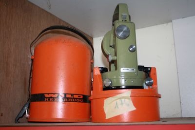 two orange buckets sitting on top of a shelf next to a green machine