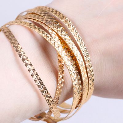 un gros plan sur le bras d'une personne portant un bracelet en or